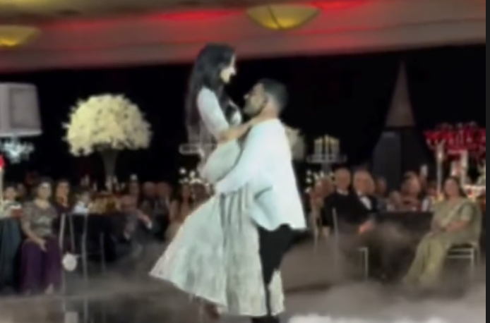 Couple's first dance lift surrounded by guests and fog effects