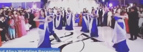 Bridesmaids dancing in blue lehengas at a wedding reception